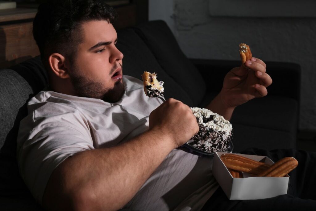 overweight man eating at night
