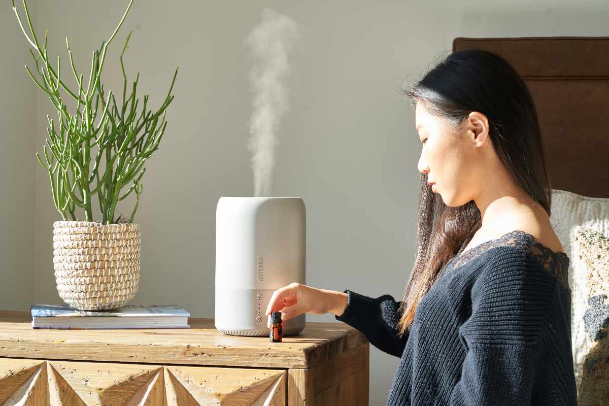 a woman using electric aromatherapy diffuser