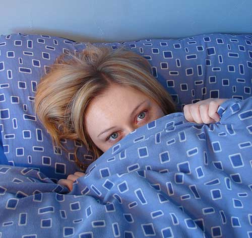 Lady under blue pattern sheets