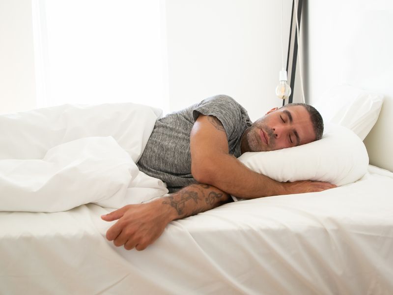Man trying to sleep with pillows to prop him up